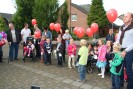 Die neuen Schüler lassen rote Luftballons steigen.