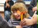 Das Foto zeigt eine lachtende Schülerin mit einem kleinen Windrad in der Hand.