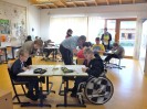 Das Foto zeigt einen Klassenraum mit Schülern, die an ihren Tischen sitzen und arbeiten.