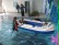 3 Schüler sitzen in einem Schlauchboot und werden über das Wasser gezogen.