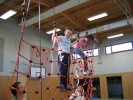 das Bild zeigt einen Schüler auf dem Klettergerüst in der Sporthalle